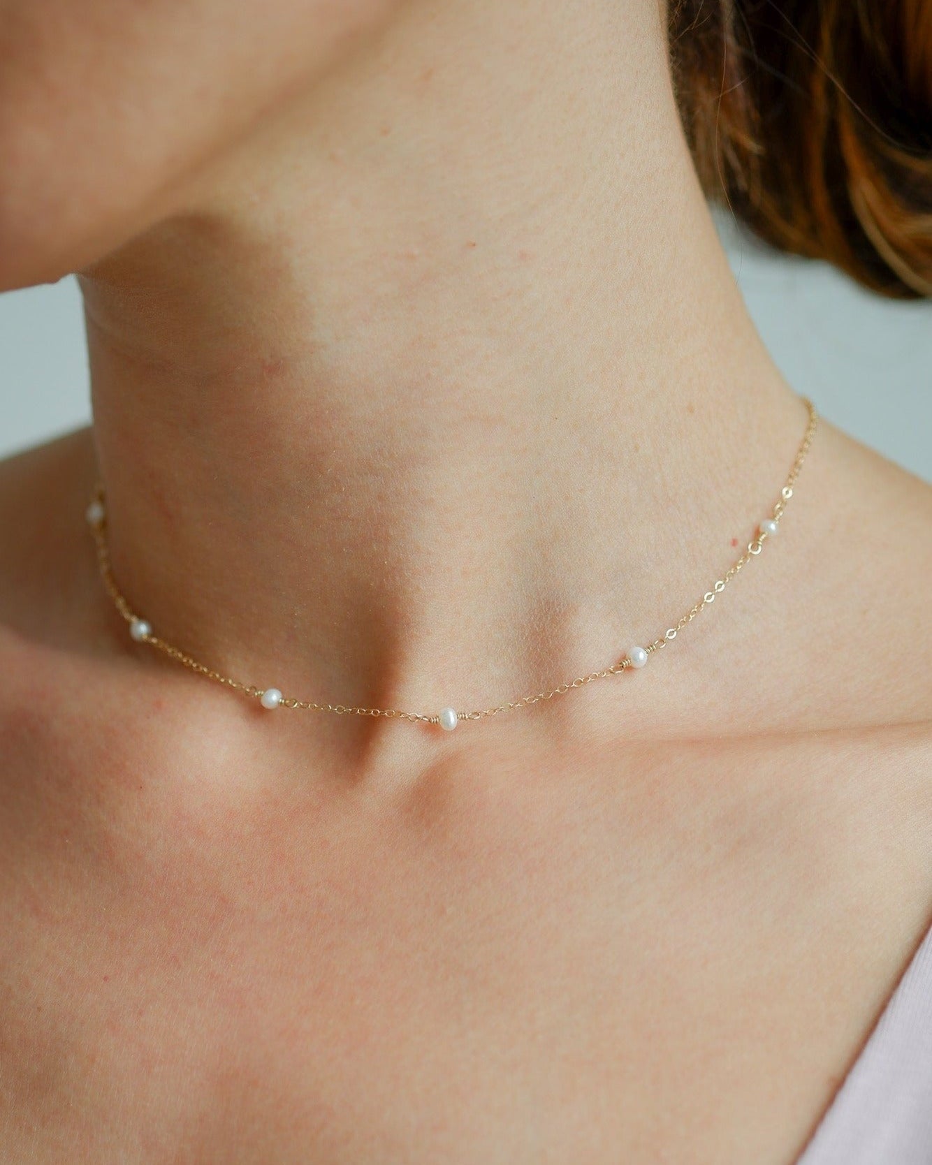 model is wearing a necklace: gold-filled chain with white freshwater pearls