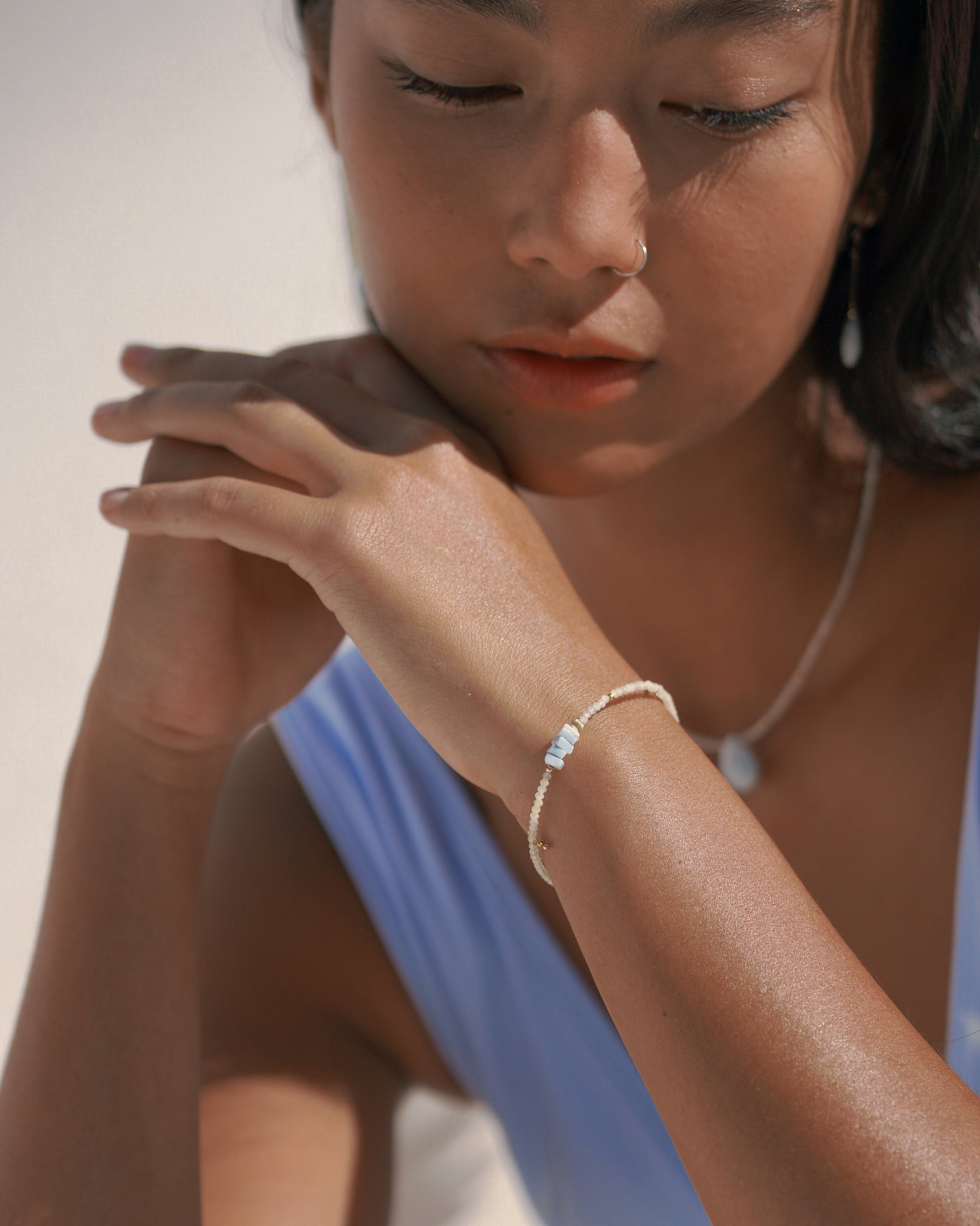 Model wearing gemstone beaded bracelet made with prehnite and blue opal gemstone
